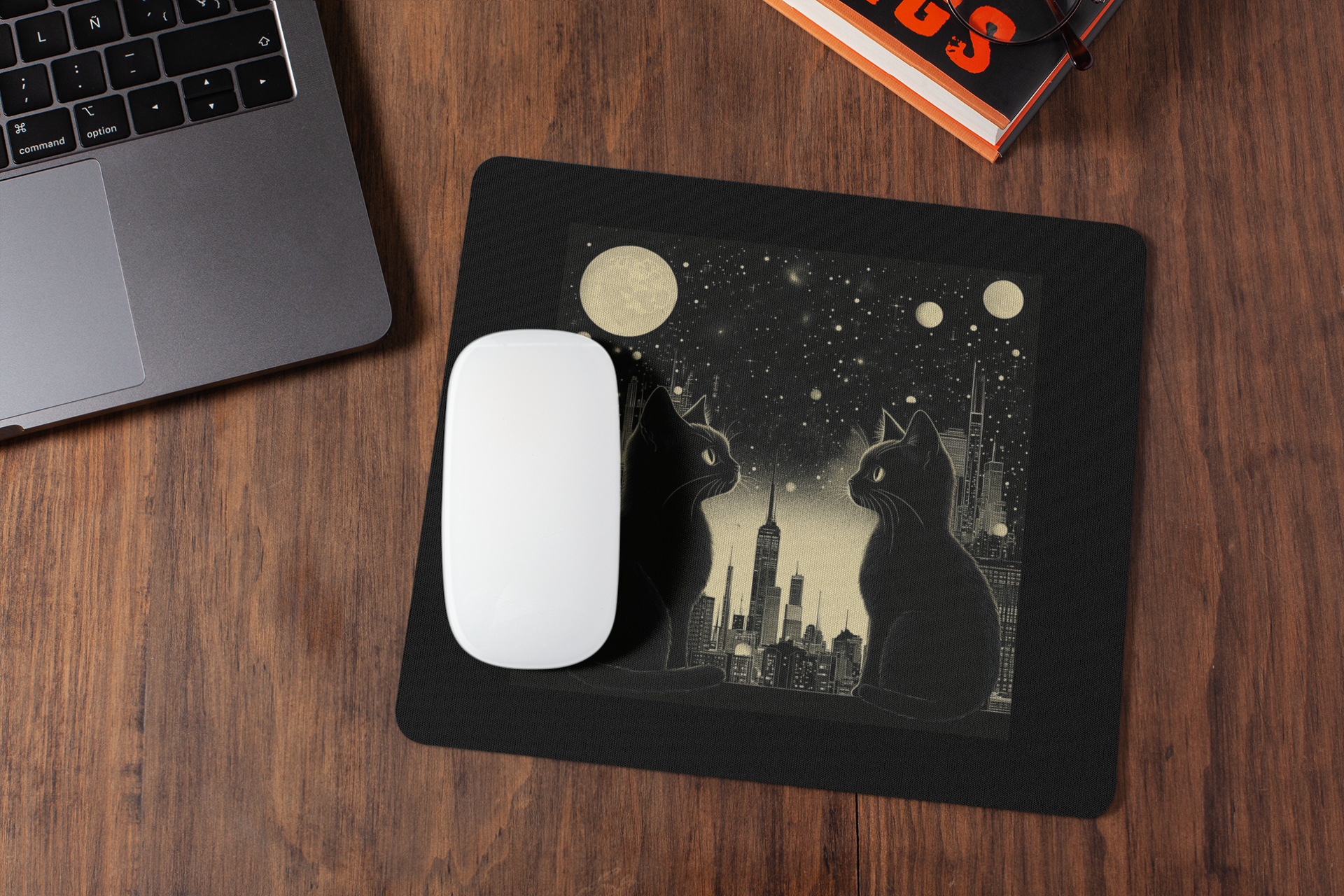The mousepad features a printed illustration of two black cats sitting in front of a city skyline under a starry night sky with moon phases.